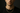 Professional product photograph of a delicate gold curb chain necklace on a young man positioned directly face-on